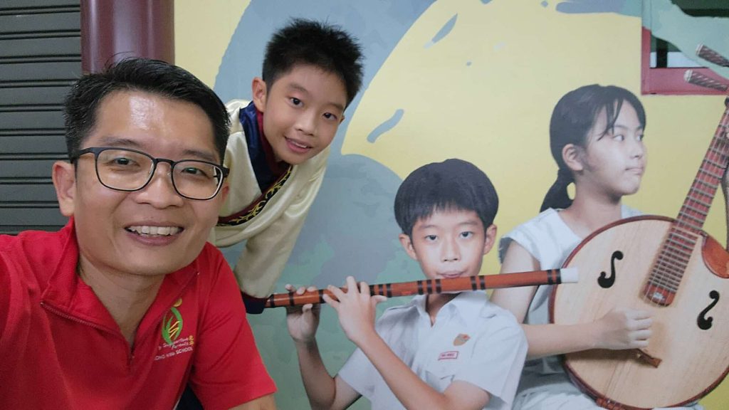 Mr-Phua-and-his-youngest-son-Wenze-with-a-photo-of-him-on-a-school-mural-1024x576.jpeg